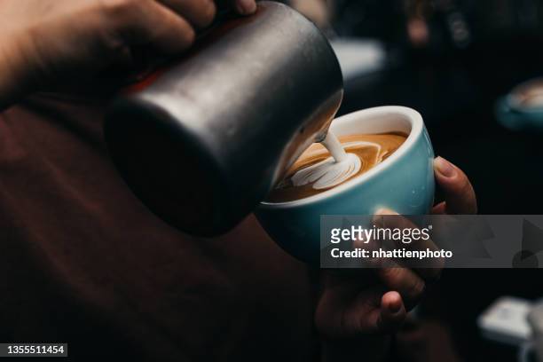 barista pouring latte art fotografie - milchschaum stock-fotos und bilder