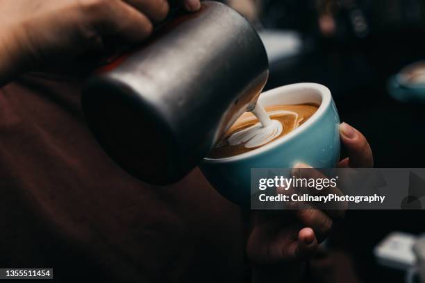 barista pouring latte art photography - melkschuim stockfoto's en -beelden