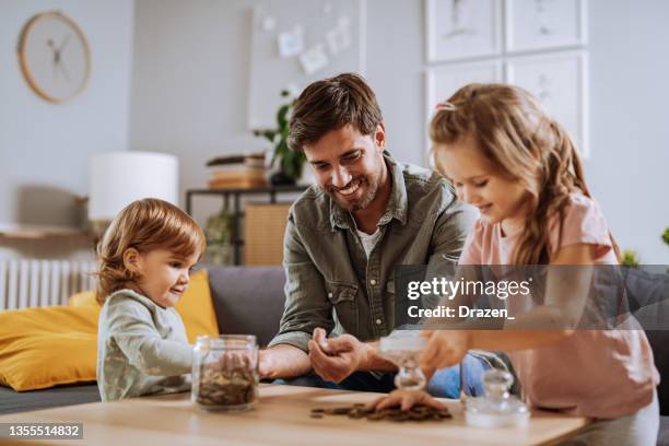 father with daughter playing - couple saving piggy bank stock pictures, royalty-free photos & images