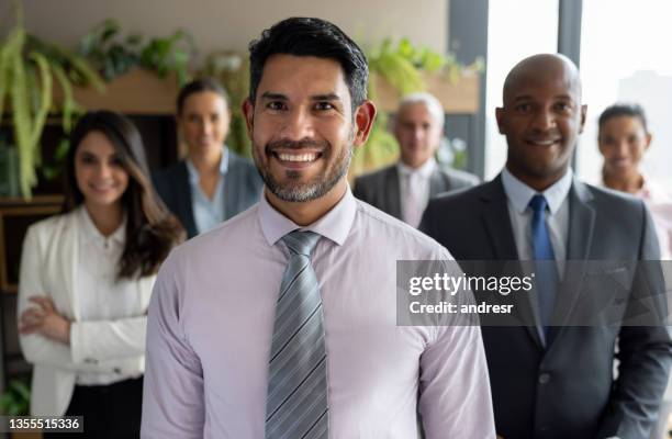 happy business man leading a team of workers at the office - male portrait suit and tie 40 year old stock pictures, royalty-free photos & images