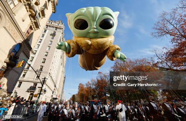 Baby Yoda, also known as the Grogu balloon floats along Central Park West in the Macy's Thanksgiving Day Parade on November 25, 2021 in New York City.