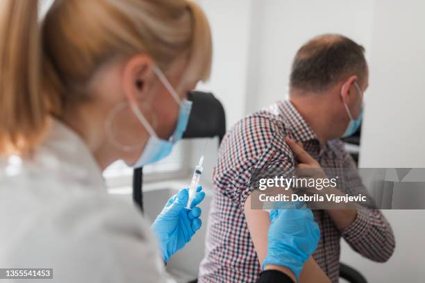 nurse taking care of the patient's vaccination wound - iv going into an arm 個照片及圖片檔
