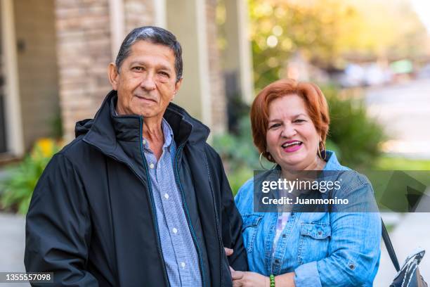 sonriente pareja hispana de la tercera edad mirando a la cámara - típico de clase mediana fotografías e imágenes de stock