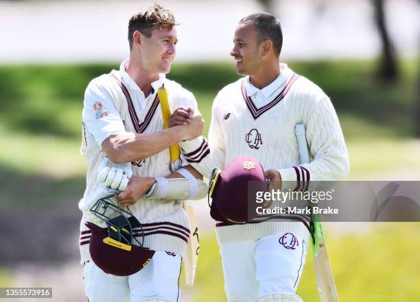 Marnus Labuschagne and Usman Khawaja of the Queensland Bulls leave the ground after hitting the winning runs during day four of the Sheffield Shield...