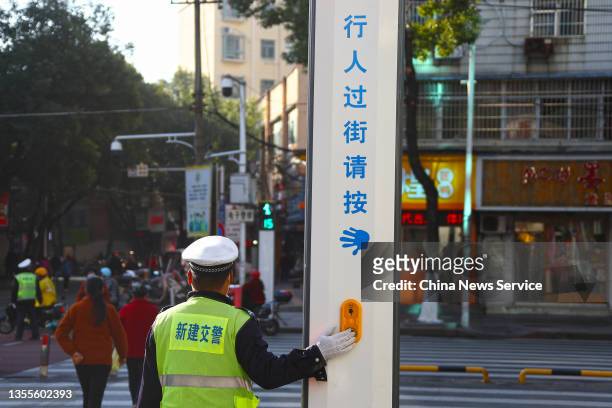 An automatic traffic light gives voice prompts after a traffic police officer presses the button for crossing the road on a street on November 25,...