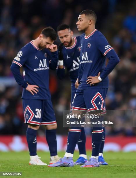 Kylian Mbappe of Paris Saint-Germain looks on as teammates Lionel Messi and Neymar talk in the background after Manchester City's first goal during...