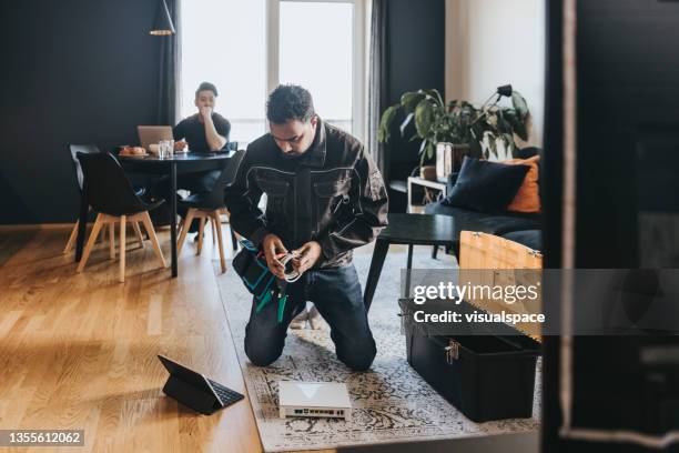 technician installing wifi router at home - modem stock pictures, royalty-free photos & images