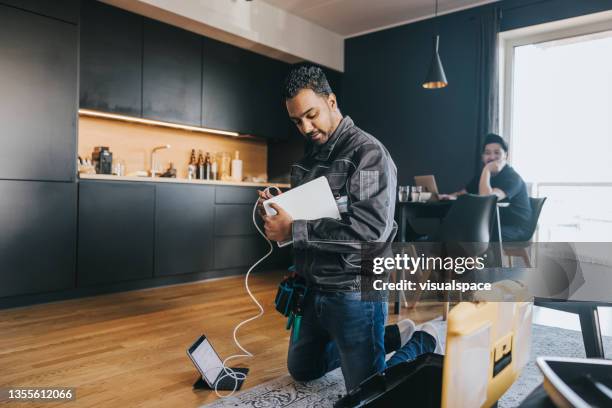 technician installing wifi router at home - plugging in stockfoto's en -beelden