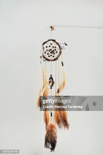 dreamcatcher with brown feathers on a white background. - bead string stock pictures, royalty-free photos & images