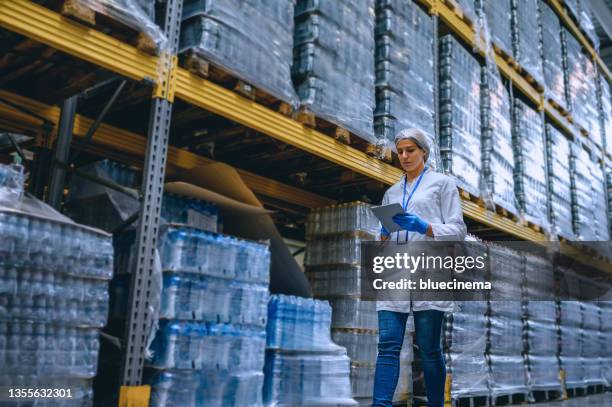 woman working at a warehouse making an inventory - bottling stock pictures, royalty-free photos & images