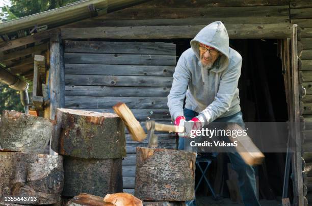 senior man chopping firewood - chopping 個照片及圖片檔