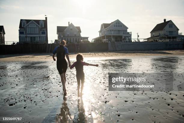 mother and daughter running on the beach at sunset. - maine stock pictures, royalty-free photos & images