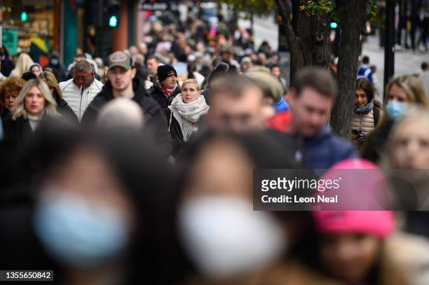 Shoppers walk through the retail district near Oxford Circus as the annual Black Friday sale event arrives, on November 26, 2021 in London, England....