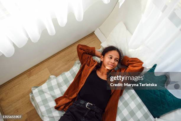 afro teenager girl lies on the bed. - bed sun stock pictures, royalty-free photos & images
