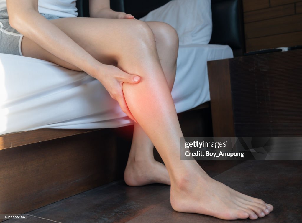 Close up of woman hand holding and massage her calf caused of suffering from calf pain.