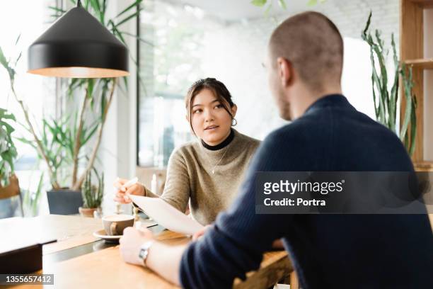 hr female manager interviewing a male interviewee - questionnaire 個照片及圖片檔