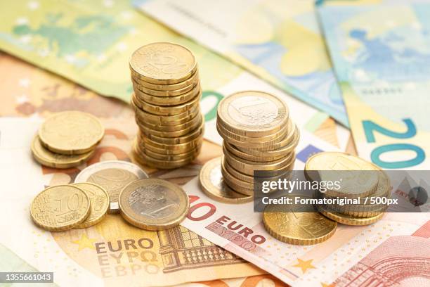 euro coins and bank notes,high angle view of coins and paper currencies on table,spain - impuestos españa fotografías e imágenes de stock