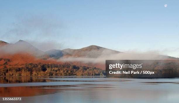 derwentwater in autumnal colour,scenic view of lake by mountains against sky,derwentwater,keswick,united kingdom,uk - nationaal monument stockfoto's en -beelden