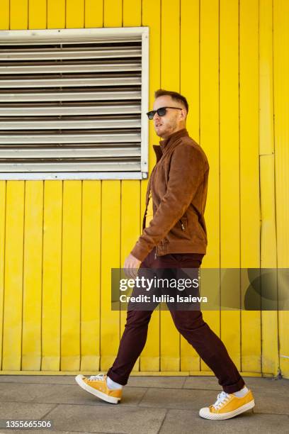 walking man in trendy outfit on street - green shoes stockfoto's en -beelden