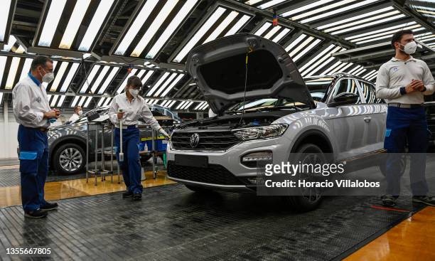 Mask-clad workers perform final quality control to new T-Roc vehicles during the visit by Portuguese Prime Minister Antonio Costa and Portuguese...