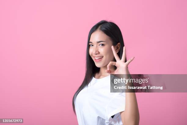 young asian woman showing a ok hand sign. - okサイン　女性 ストックフォトと画像