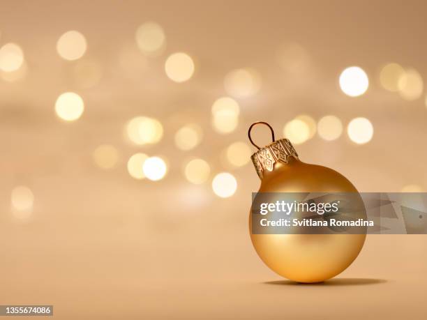golden christmas ornament on golden background with defocused lights - knick knack stock pictures, royalty-free photos & images