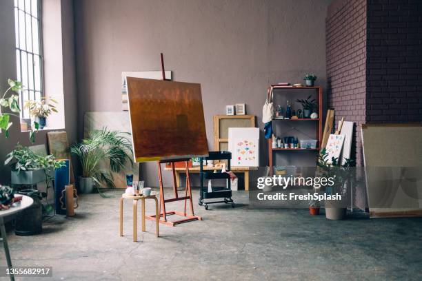 painter's workspace: a painting on an easel in an art studio - kunstatelier stockfoto's en -beelden