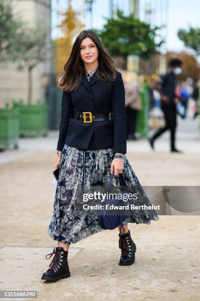 Guest wears a navy blue with white flower print pattern long flowing dress, a black blazer jacket, a black shiny leather D gold buckle belt from...