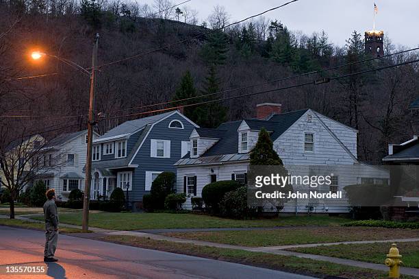 50 year old caucasian man standing at dawn in a residential neighborhood in greenfield, massachusetts with poet's seat tower in the background - greenfield massachusetts stock pictures, royalty-free photos & images