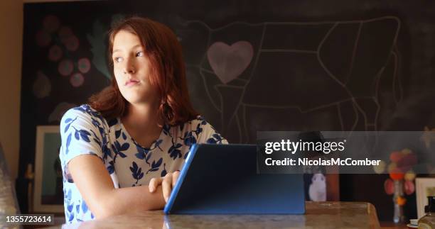 adolescente aburrida y desaproyidadda por los medios de comunicación en la tableta digital - american red cross fotografías e imágenes de stock