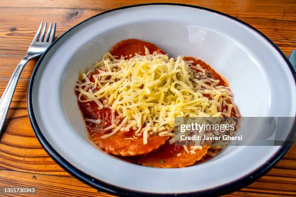 pasta rellena argentina: sorrentinos de boniato con salsa de tomate y queso rallado (comida vegetariana) - comida vegetariana stockfoto's en -beelden