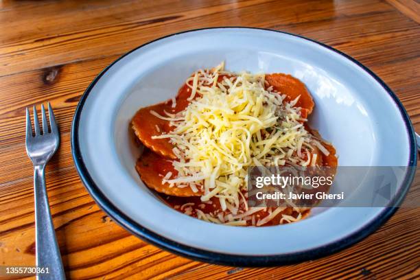 pasta rellena argentina: sorrentinos de boniato con salsa de tomate y queso rallado (comida vegetariana) - comida vegetariana stockfoto's en -beelden
