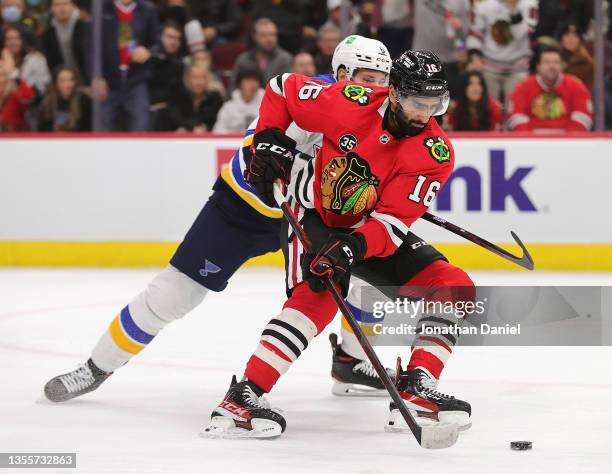 Jujhar Khaira of the Chicago Blackhawks advances the puck under pressure from Marco Scandella of the St. Louis Blues at the United Center on November...