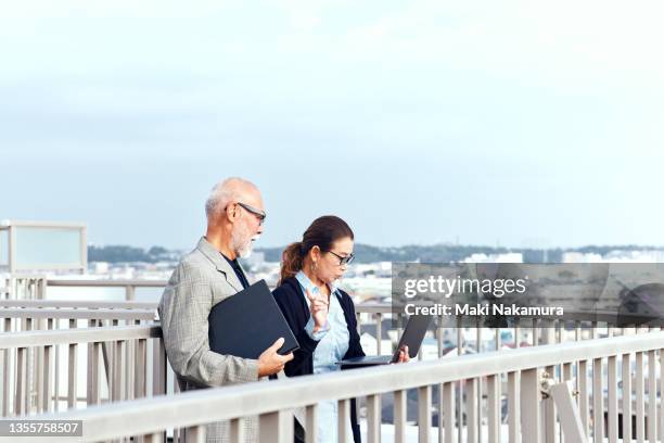 adult businessman having a meeting on the roof of a building - odds stockfoto's en -beelden