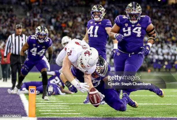 Max Borghi of the Washington State Cougars scores a touchdown against Jackson Sirmon of the Washington Huskies during the first quarter at Husky...