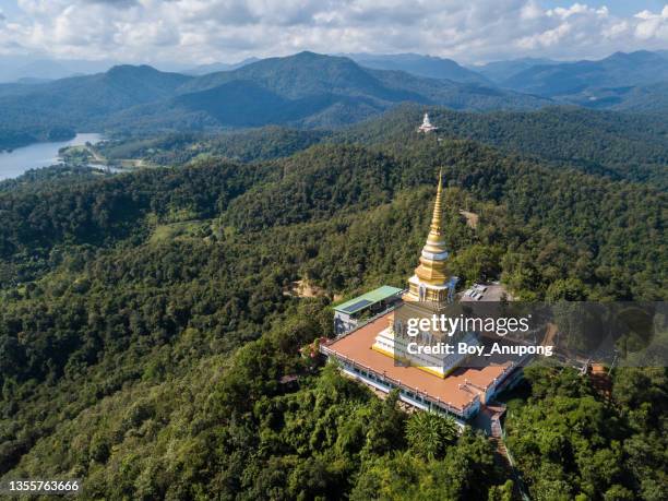 aerial view of the large pagoda in wat phrathat mon phrachao lai located on mountain elevation above seal level is 618 metres in chiang rai province, thailand. - theravada stock pictures, royalty-free photos & images