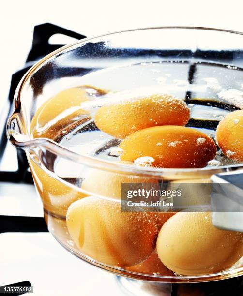 eggs boiling in glass pan on hob - boiled stock pictures, royalty-free photos & images