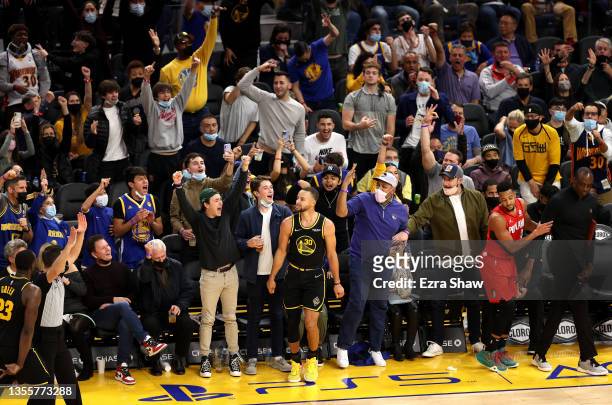 Fans react after Stephen Curry of the Golden State Warriors made a three point basket in the fourth quarter against the Portland Trail Blazers at...