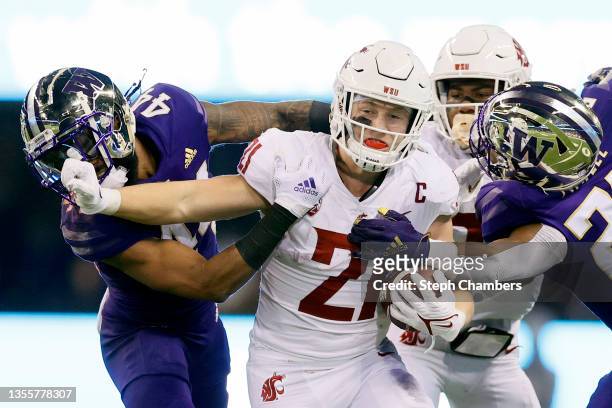 Max Borghi of the Washington State Cougars carries the ball against Brendan Radley-Hiles of the Washington Huskies during the third quarter at Husky...