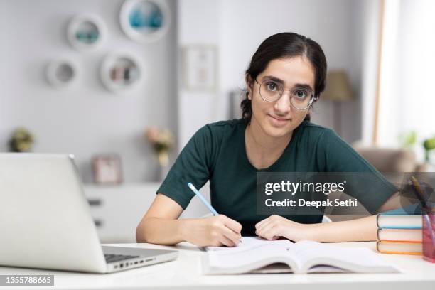 teenage girl doing homework at home stock photo - girls stock pictures, royalty-free photos & images