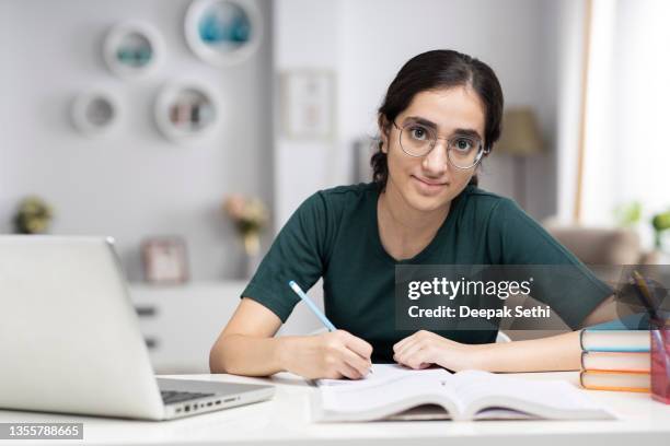 teenage girl doing homework at home stock photo - teenager studying stock pictures, royalty-free photos & images