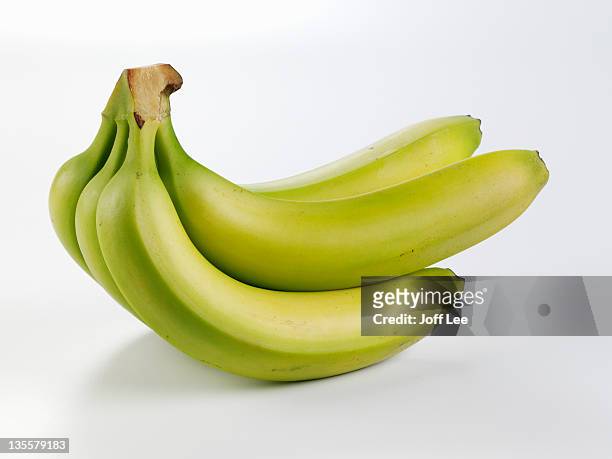 bunch of unripe bananas - banane stock-fotos und bilder