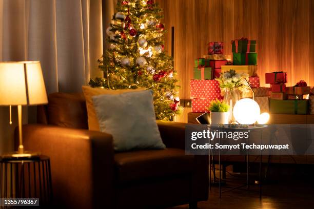 home inerior in christmas night holiday,brown leather armchair with christmas decorating tree and table lamp in living room at home - ornate chair stock pictures, royalty-free photos & images