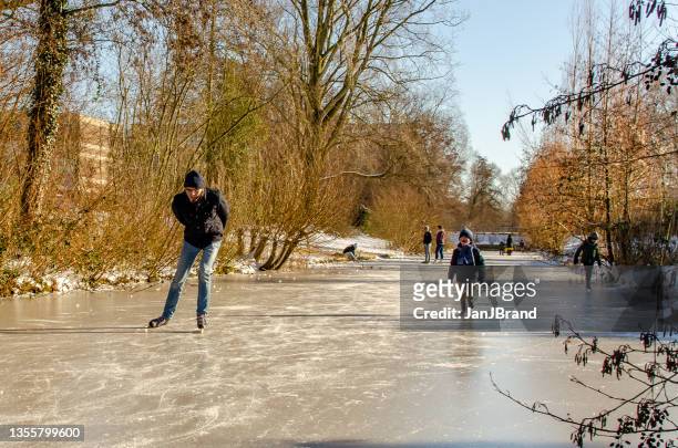 people skating on frozen ditch - veluwemeer stockfoto's en -beelden