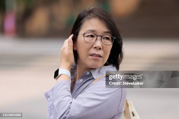 woman looking behind her - looking over shoulder scared stock pictures, royalty-free photos & images