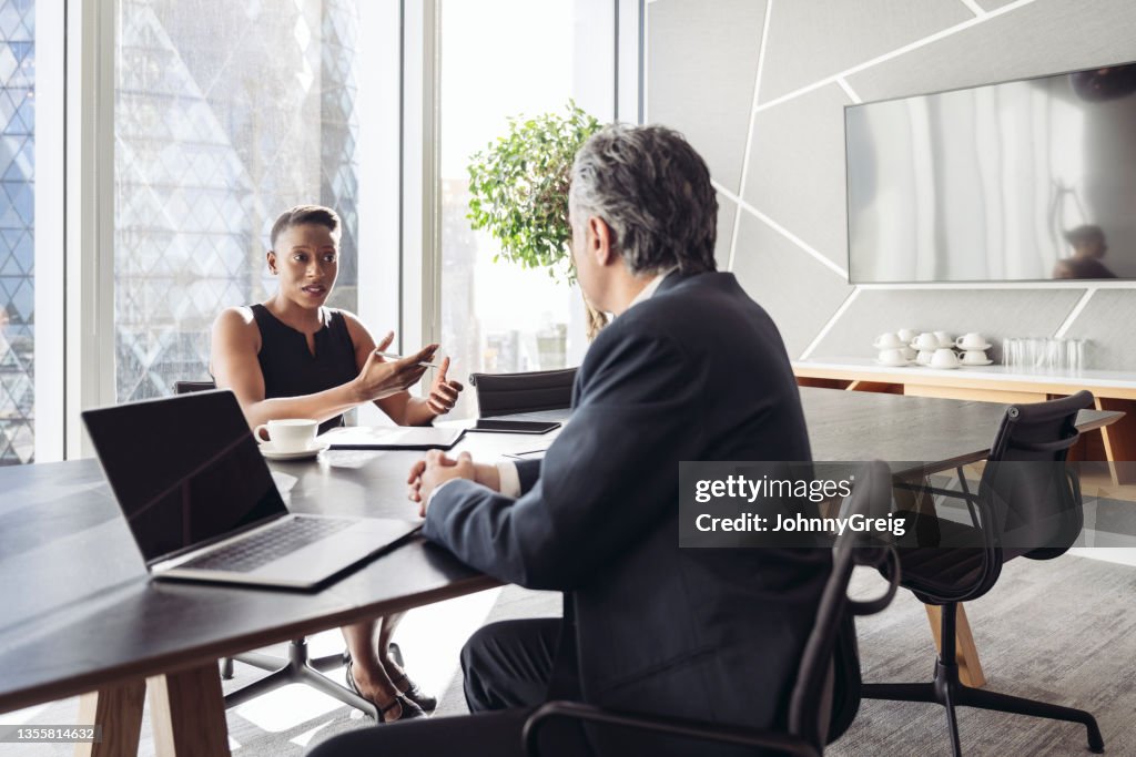 British investment managers conversing in board room