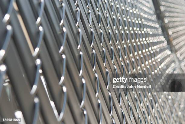 sunlight glistening on a chainlink fence - recinzione foto e immagini stock