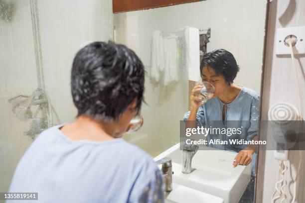 brushing teeth in front of a mirror - gargling stock pictures, royalty-free photos & images