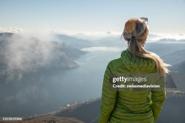 woman hiking on mountain top, lake view - aiming higher stock pictures, royalty-free photos & images