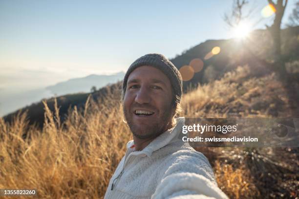 man hiking takes a selfie at sunset - self portrait photography stockfoto's en -beelden